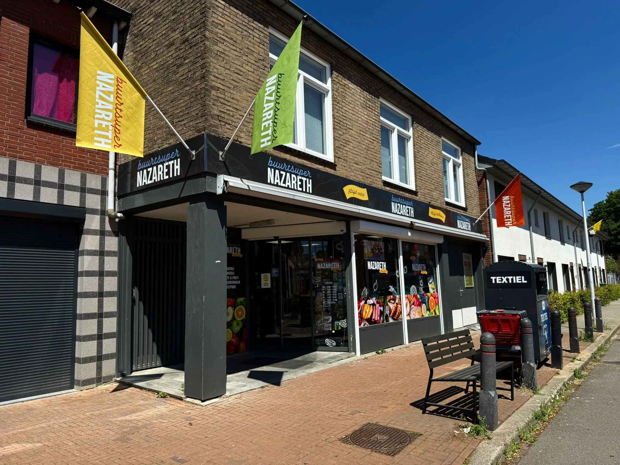 Buitenreclame door middel van gevelbord, vlaggen en raambestickering voor Winkel in Maastricht