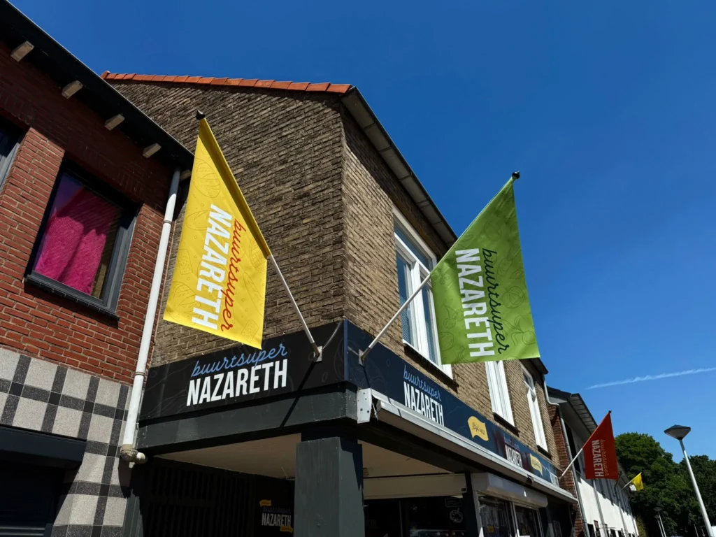 Vlaggen reclame voor kleine supermarkt in Maastricht